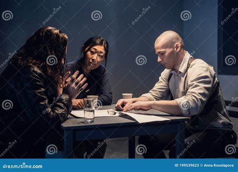 A Police Detective At The Station And His Partner An Asian Woman