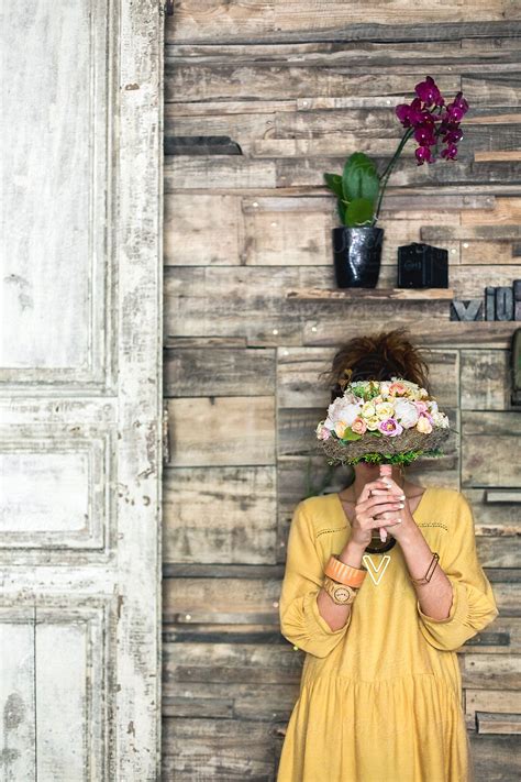 Woman Holding Flowers In Front Of Her Face Del Colaborador De Stocksy