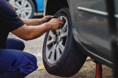 Concept de remplacement de pneu Mécanicien travaillant avec roue dans