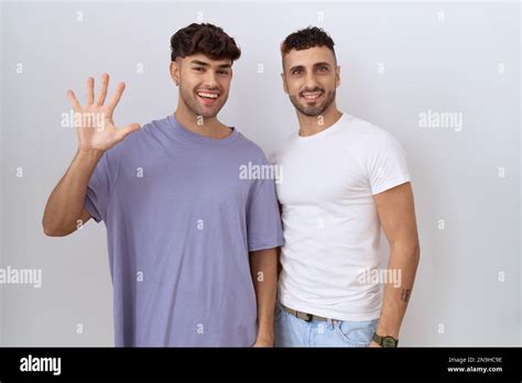 Homosexual Gay Couple Standing Over White Background Showing And Pointing Up With Fingers Number