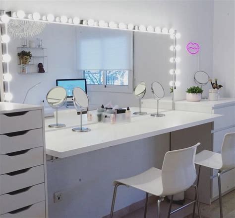 A White Desk Topped With Lots Of Mirrors And Lights