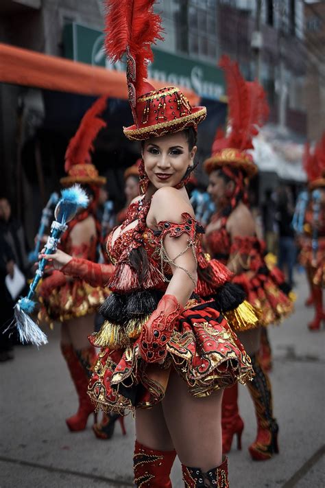 A Woman Dressed In Red And Gold Is Walking Down The Street