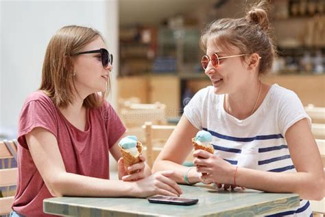 Horizontal Shot Of Two Cheerful European Girls Wears Trendy Sunglasses