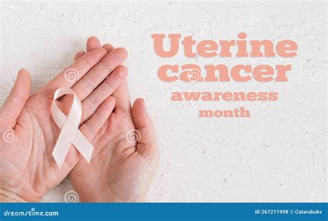 Adult Hands Holding Peach Ribbon Uterine Cancer Awareness Month