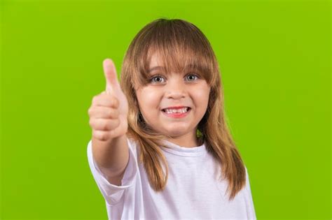 Adorável menina sorrindo alegremente fazendo um sinal de polegar para