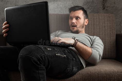 A Man Watches An Adult Video On A Laptop While Sitting On The Couch The Concept Of Porn