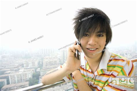 Teenage Boy Using Cell Phone Cityscape In Background Stock Photo