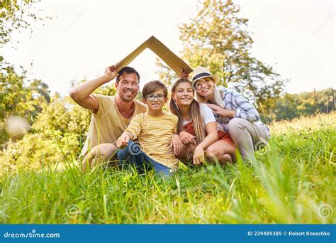 Familia Con Dos Ni Os Con Techo Sobre Sus Cabezas Imagen De Archivo