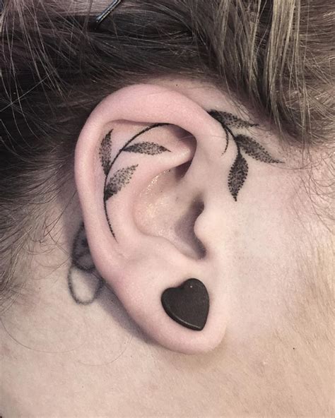 Black leaf tattoo on the ear - Tattoogrid.net