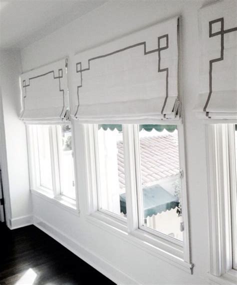 Three Windows With Roman Blinds In A White Room