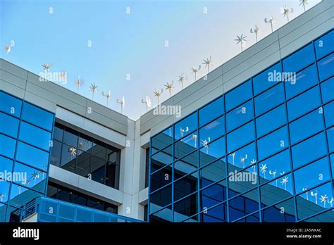 Wind Turbines Producing Energy On Top Of Modern Office Building On A