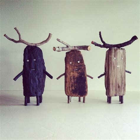 Three Wooden Sculptures Made To Look Like People With Antlers On Their