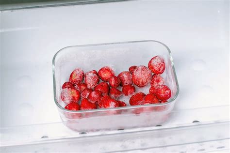 Frozen Strawberries In A Plastic Container In The Freezer Stock Image