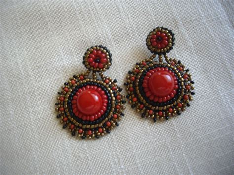 Red And Black Beaded Earrings On White Fabric