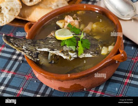 Thick Fish Soup With Sturgeon Head Served With Lemon And Greens In