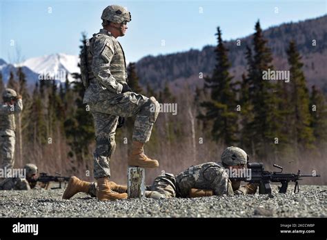 Us Army Soldier Watches A Fellow Soldier Fire An M249 Squad Automatic