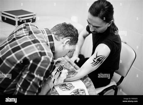 Tattoo Master Make Tattoo For Rocker Man At Tattoo Salon Stock Photo