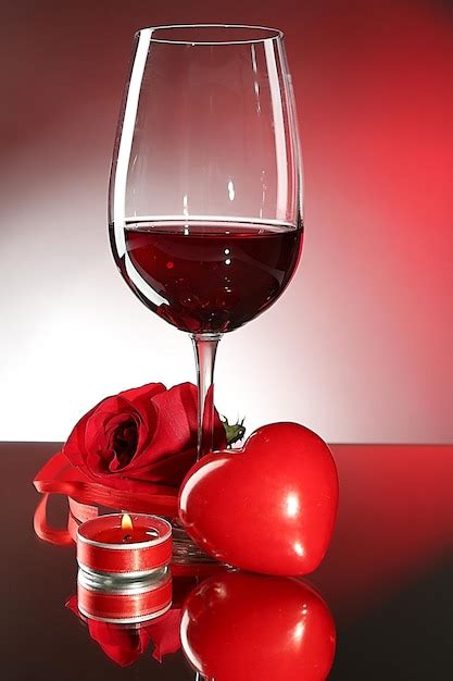 Composição vinho tinto em vidro rosa vermelha e coração decorativo