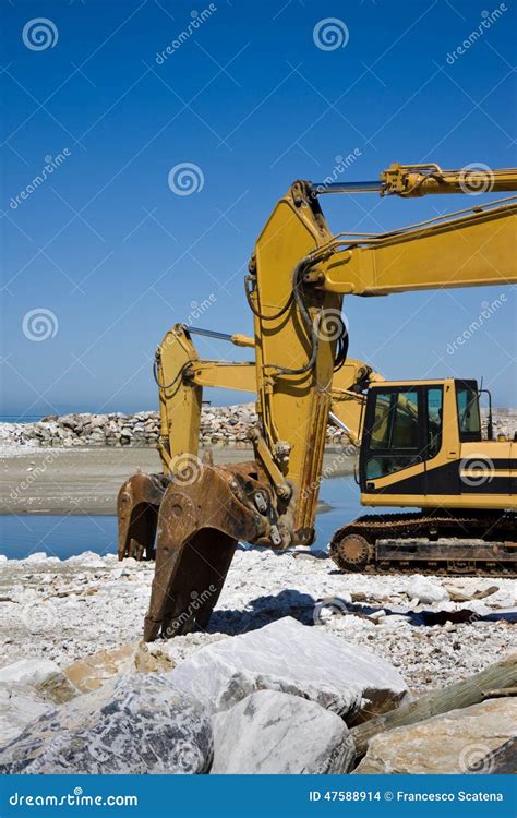 Yellow Diggers On The Seashore Stock Photo Image Of People Overflow