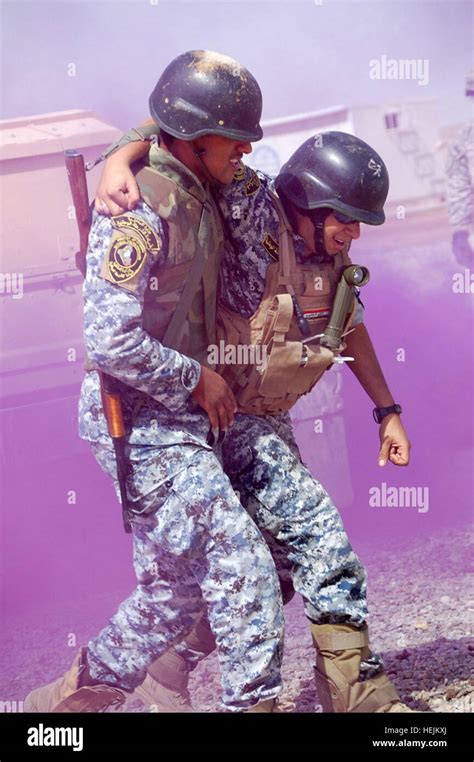 An Iraqi Federal Police Officer Helps A Fellow Officer After A Make