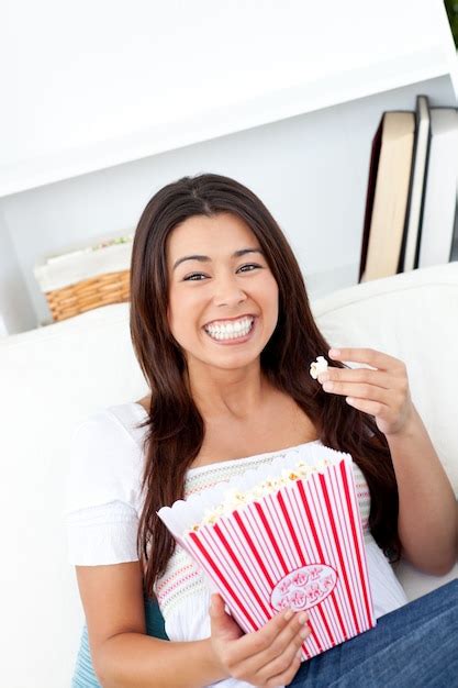 Premium Photo Cheerful Asian Woman Sitting On Sofa And Eating Popcorn