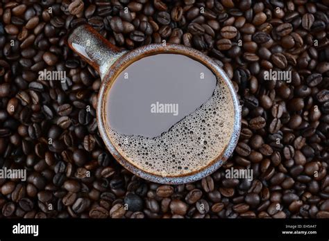 High Angle Shot Of A Coffee Mug Surrounded By Fresh Roasted Beans Stock