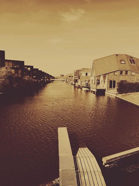 Premium Photo River Amidst Houses Against Sky At Sunset