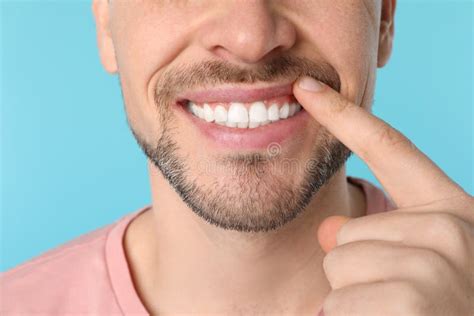 Uomo Sorridente Che Mostra I Denti Perfetti Sul Fondo Di Colore