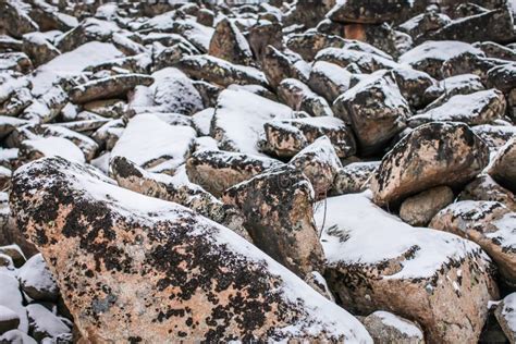 Pedras Enormes Dos Pedregulhos Do Granito Na Neve Em Formas E Em