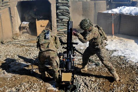 A Us Soldier Loads A Round Before Firing Their 120mm Mortars During A