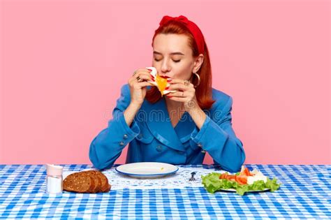 Young Redhead Woman Sitting At Table With Checkered Tablecloth And