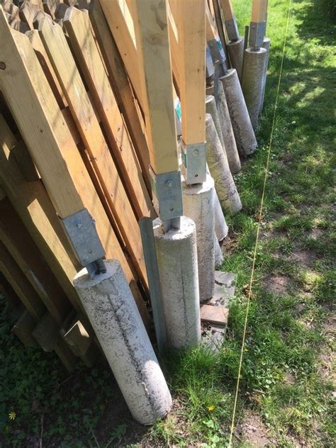 Several Cement Poles Are Lined Up Next To Each Other In The Grass Near