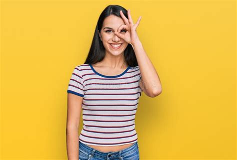 Young Hispanic Girl Wearing Casual Striped T Shirt Doing Ok Gesture