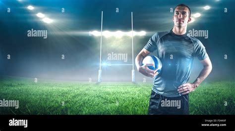 Composite Image Of Rugby Player Holding Ball With Hand On Hip Stock