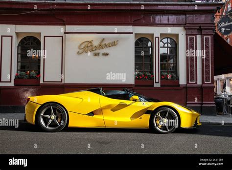 Yellow Ferrari LaFerrari Aperta modern supercar parked at a cafe in Mayfair area of Central ...