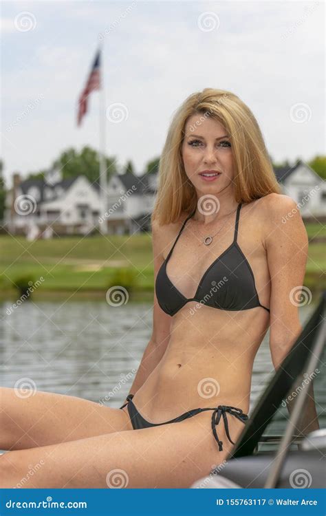 Beautiful Bikini Model Relaxing On A Boat By The Docks Stock Image