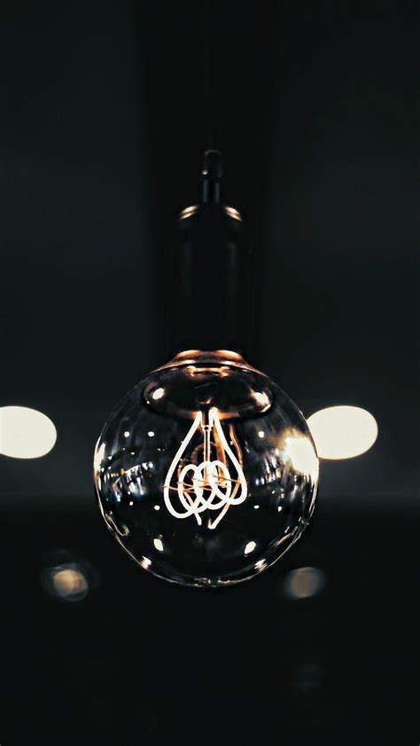 A Light Bulb That Is Lit Up With Some Lights In The Background And On