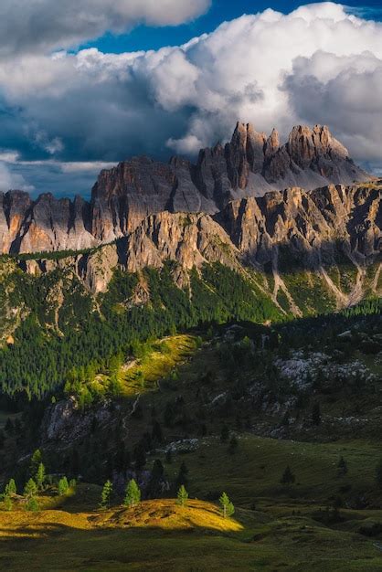 Premium Photo Vertical Shot Of Rocky Mountains With Green Trees In A