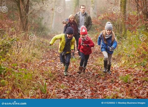 Famiglia Che Cammina Attraverso Il Terreno Boscoso Di Inverno