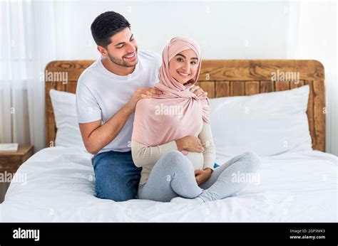 Caring Arab Husband Massaging Shoulders Of His Young Arab Pregnant Wife