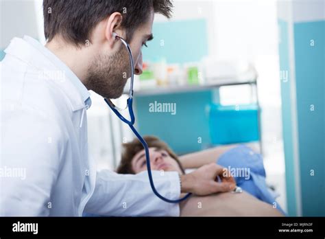 Doctor examining patient's heartbeat with a stethoscope Stock Photo - Alamy