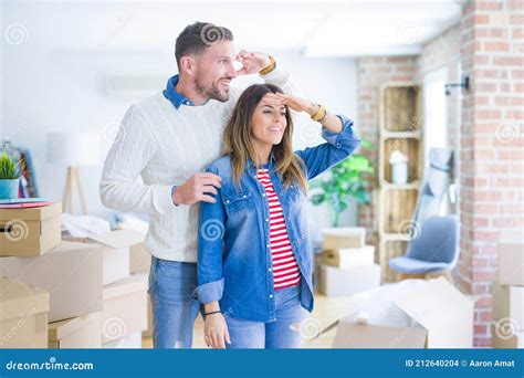 Young Beautiful Couple Standing At New Home Around Cardboard Boxes Very