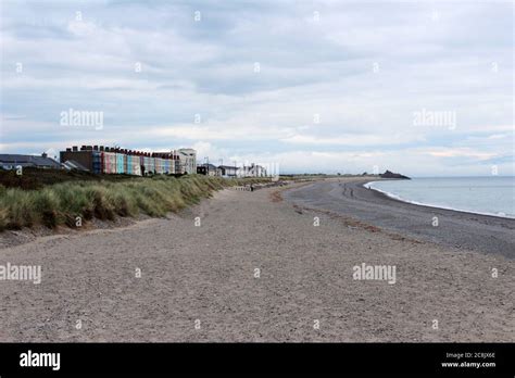 Pwllheli beach, inc beachgrass, the sea and the seaside town of Pwllheli, North Wales Stock ...