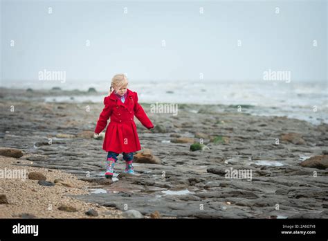 Young Girl Walks Alone Along A Beach Fotos Und Bildmaterial In Hoher Auflösung Alamy