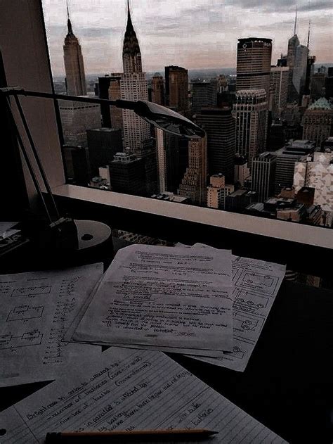 some papers are sitting on top of a desk in front of a window with a ...