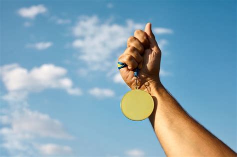 M O De Vencedor Levantada E Segurando A Medalha De Ouro Fita Contra