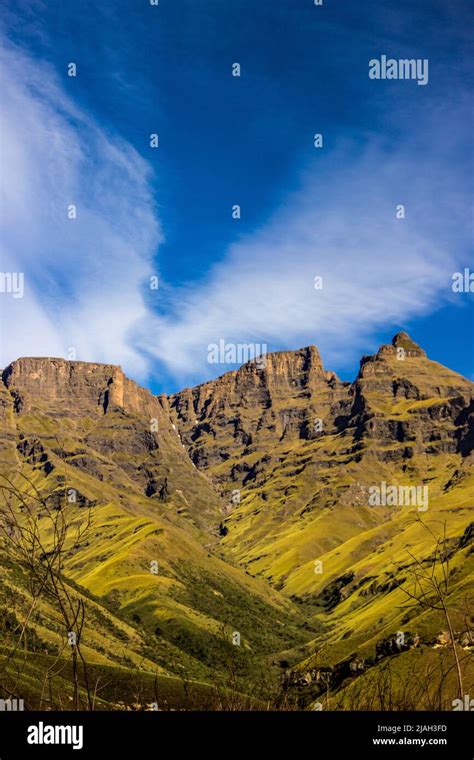 The tall craggy cliffs of the Drakensberg Mountains, with late season snow still slightly ...