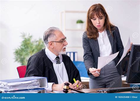 Old Male Judge And His Young Secretary In The Office Stock Photo