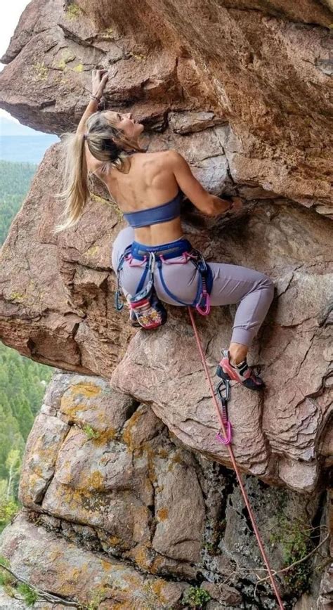 A Woman Climbing Up The Side Of A Mountain With Her Hands In Her