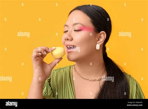 Beautiful Asian Woman Eating Tasty Japanese Mochi On Color Background